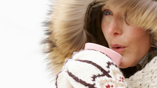 Woman holding warm drink in winter